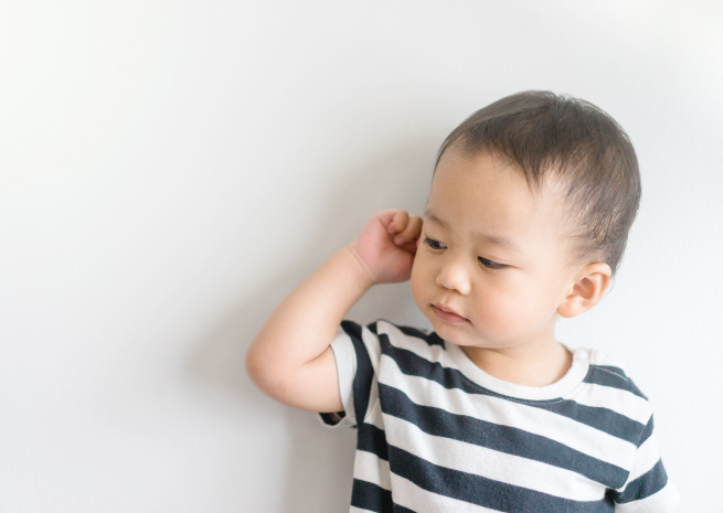Child holding ear 